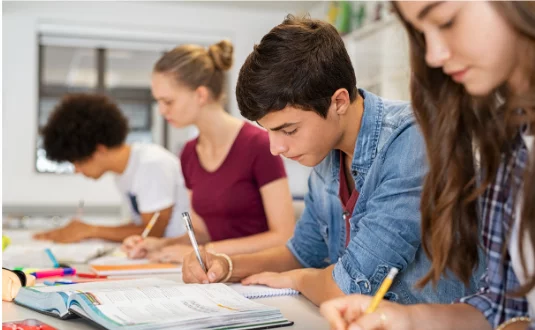 Stock photo of students writing at their school desks
